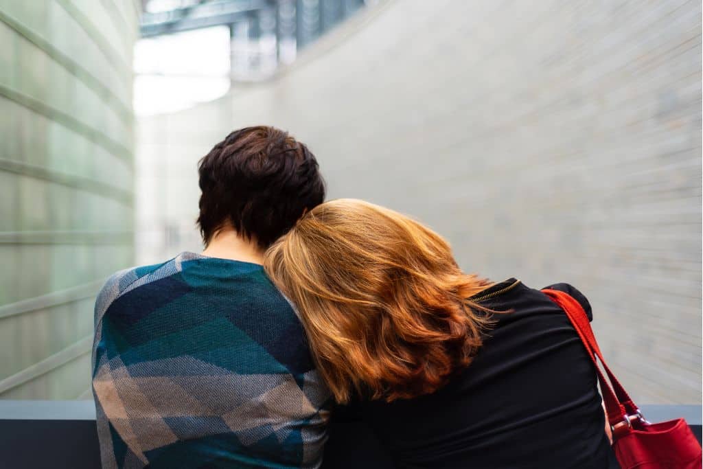 A young couple resting their heads on each other's shoulders in support of their alcohol addictions - Which Rehab