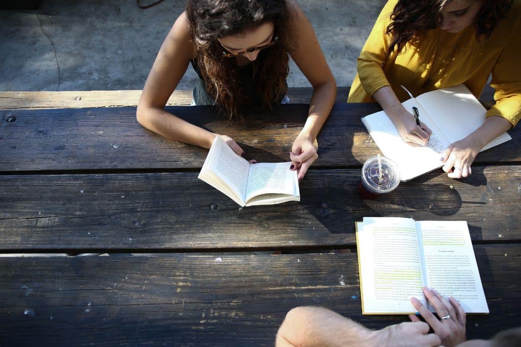 People sat on a park bench journaling as part of a rehab therapy - Which Rehab