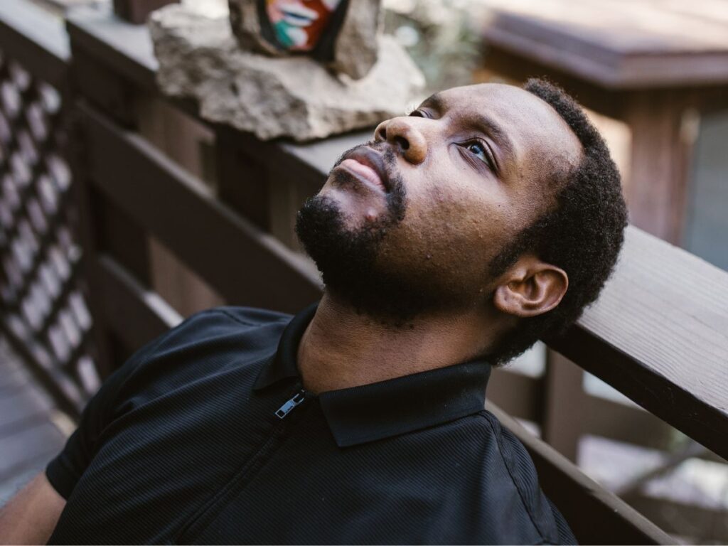Man resting his head on a balcony suffering with PTSD - Cognitive Processing Therapy - Which Rehab