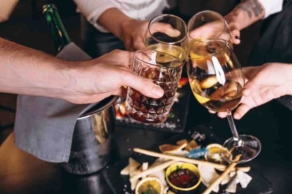 A group of people cheering their drinking at Christmas - Which Rehab