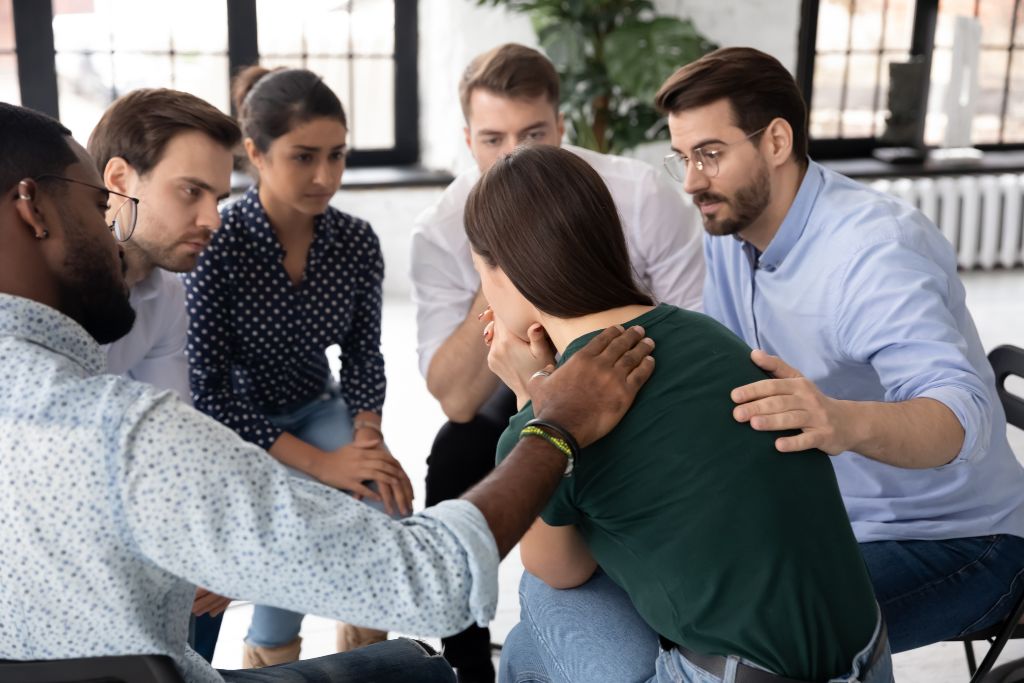 A woman being supported by her peers in a alcohol group therapy session - - the 4 treatments of alcoholism - Which Rehab